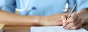 female doctor holding pen and writing