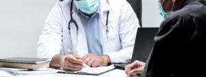 stock photo of doctor talking to patient over clipboard