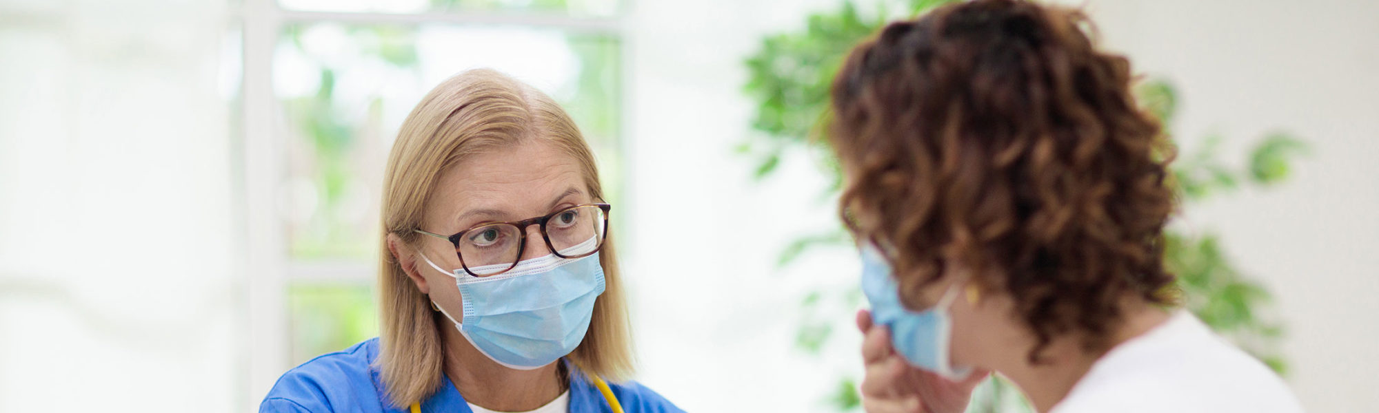 female nurse talking to patient with face mask