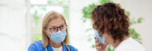 female nurse talking to patient with face mask