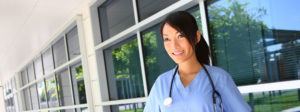 Doctor standing outside near the hospital wearing her stethoscope around her neck